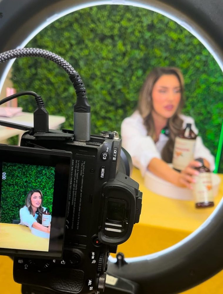 Host presenting a product on camera through a ring light in DCA’s studio