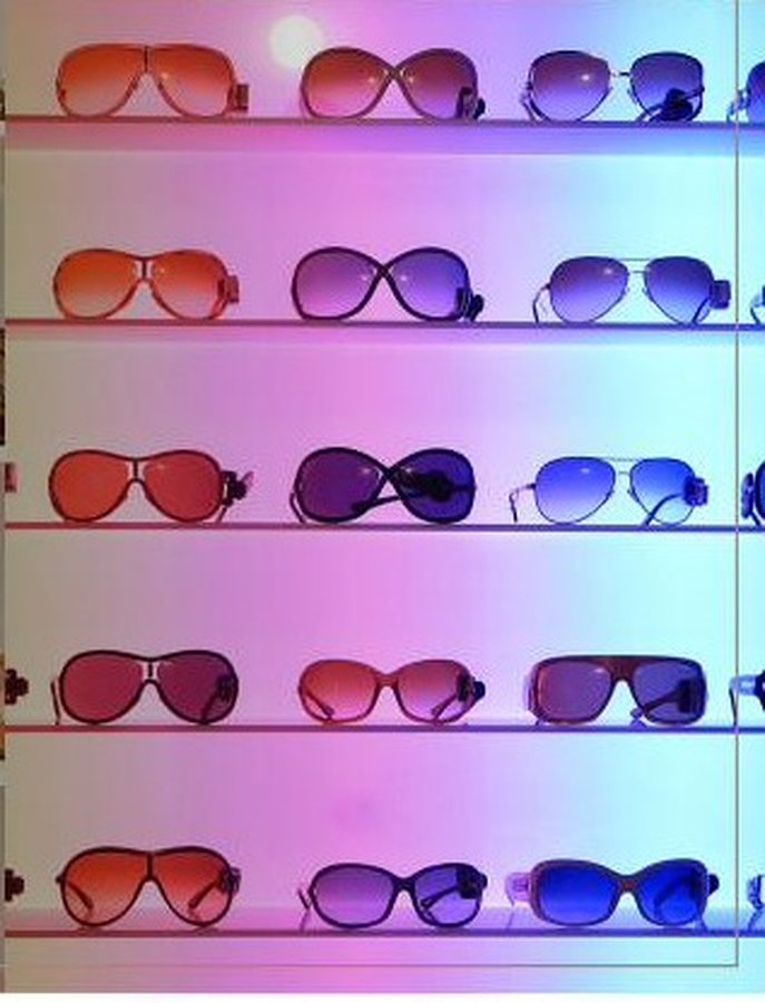 Sunglasses arranged on backlit retail shelving